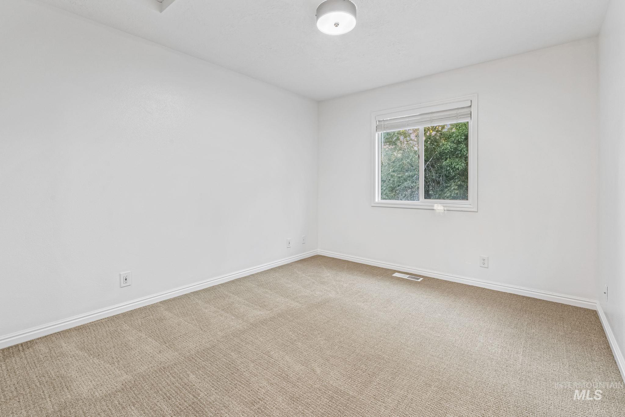 Empty room featuring carpet and baseboards