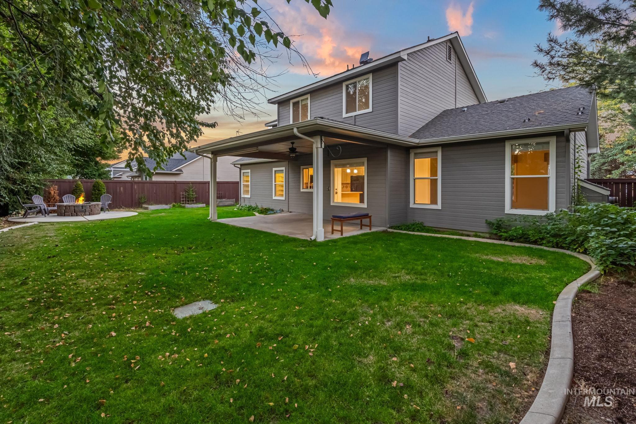 Rear view of property featuring a patio area, a fenced backyard, a ceiling fan, and a chimney