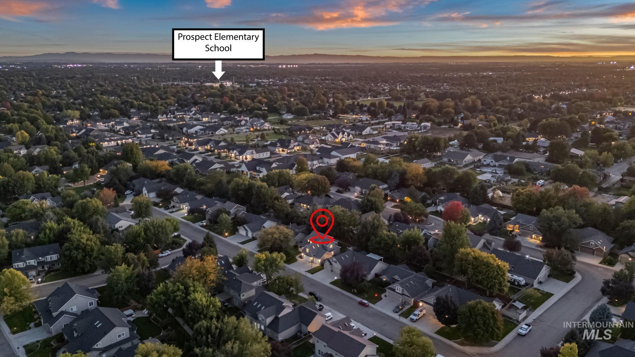 Aerial view of property and surrounding area featuring nearby suburban area and a mountainous background