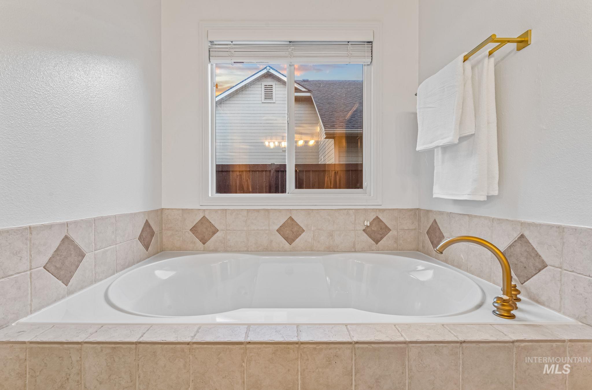Bathroom featuring a bath and a textured wall