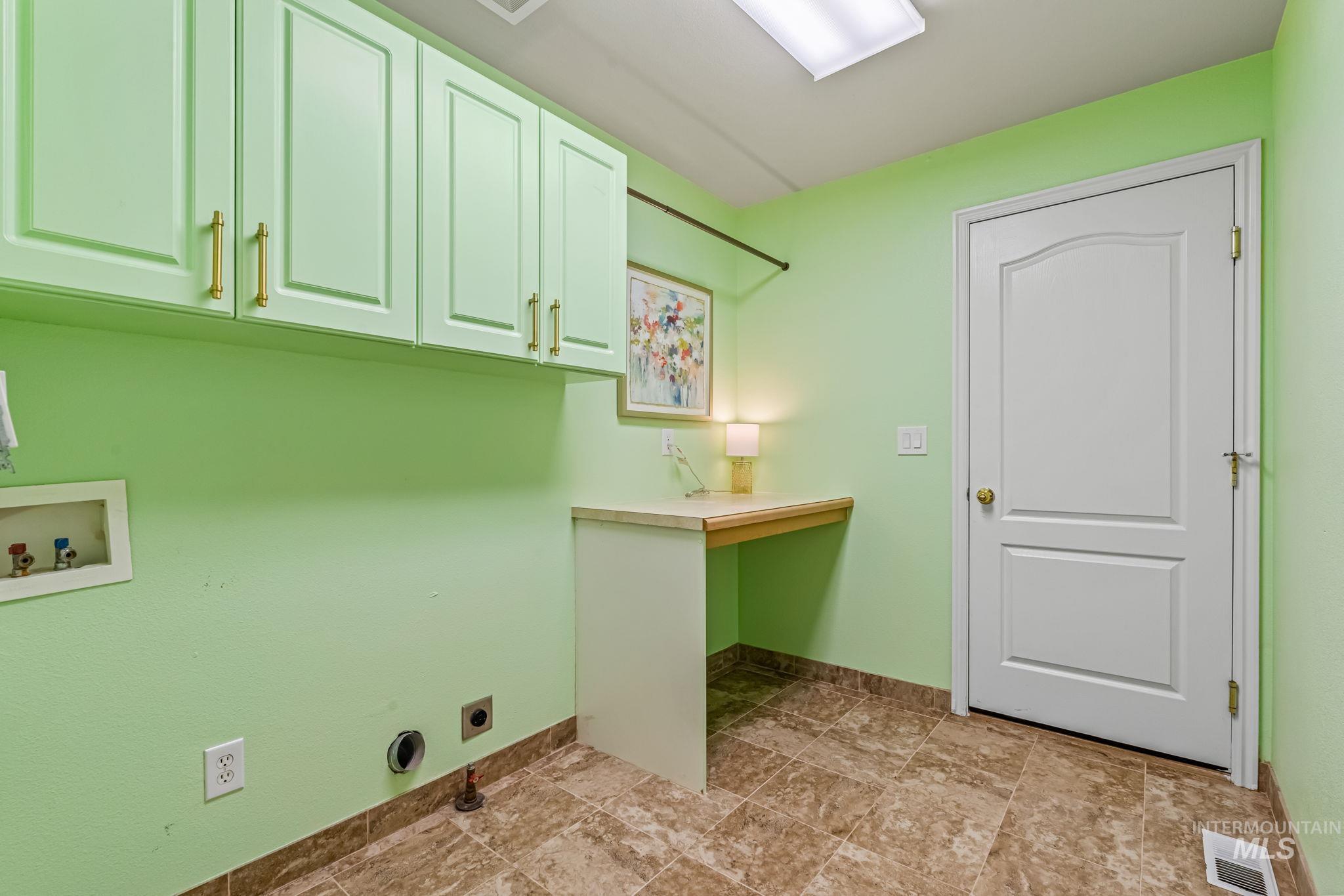 Laundry room featuring hookup for a washing machine, electric dryer hookup, and cabinet space