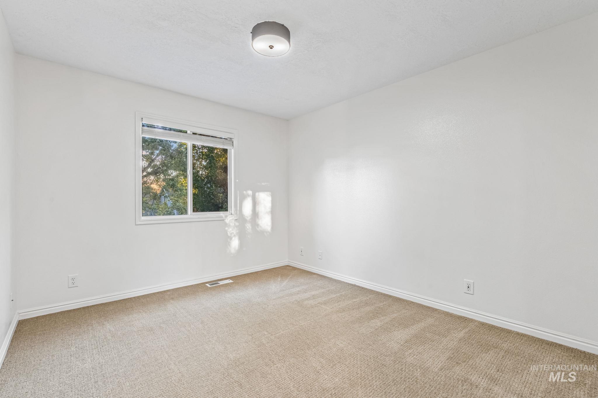 Empty room with carpet flooring and baseboards