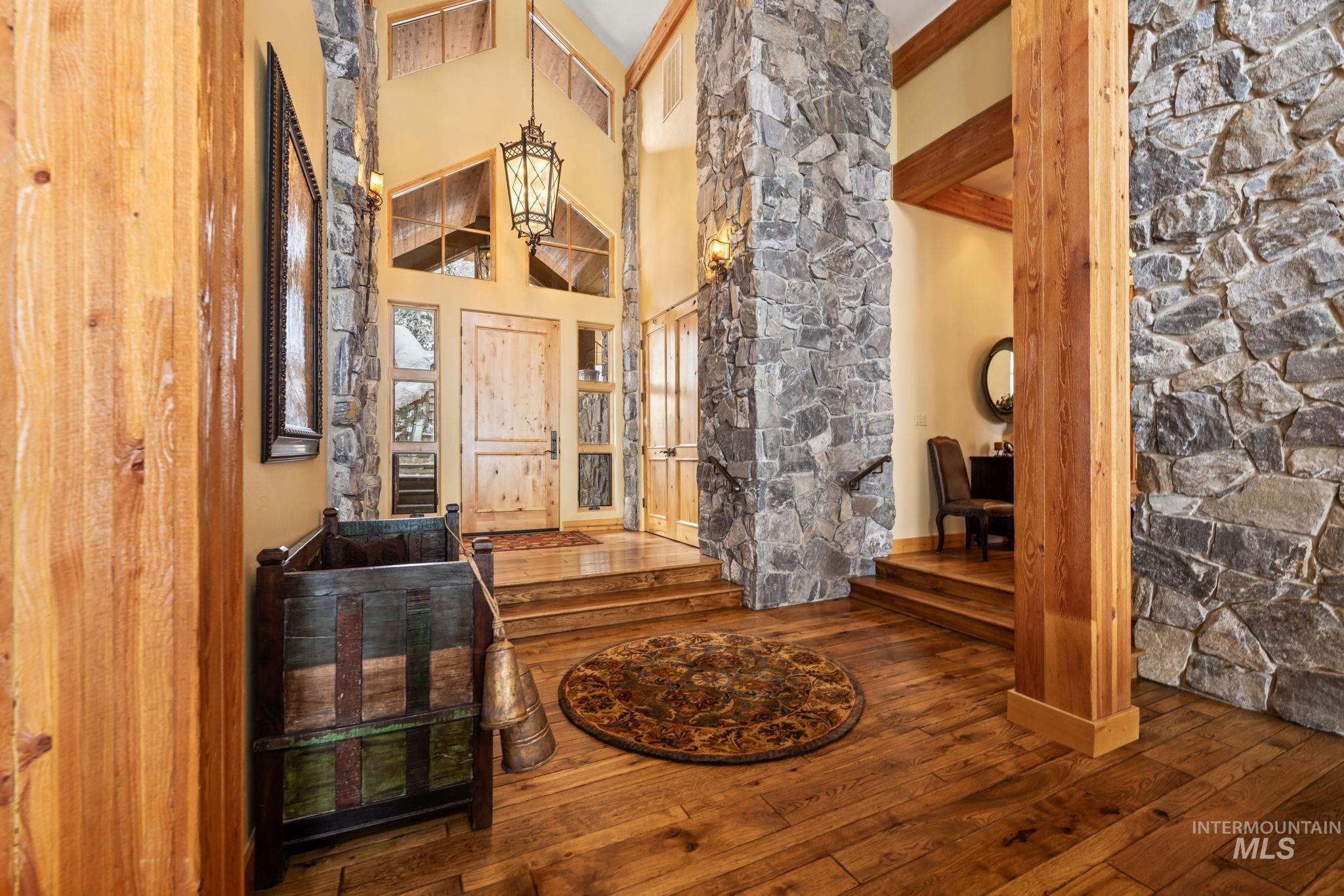 Entryway with a high ceiling, hardwood / wood-style flooring, and beam ceiling