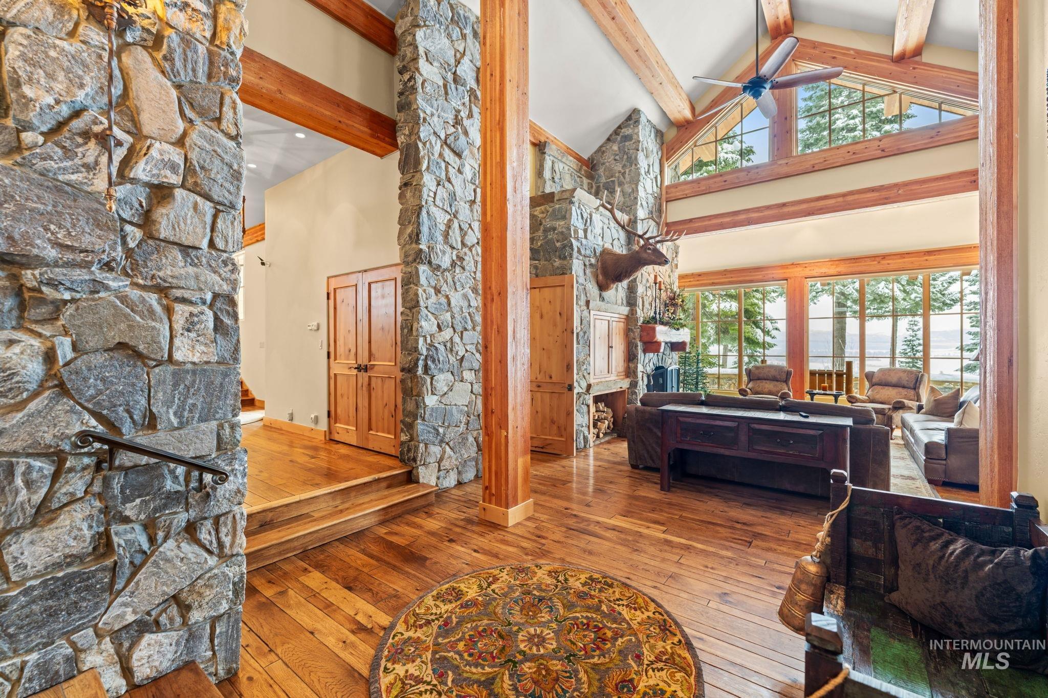 Entrance foyer with high vaulted ceiling, wood-type flooring, beam ceiling, and ceiling fan