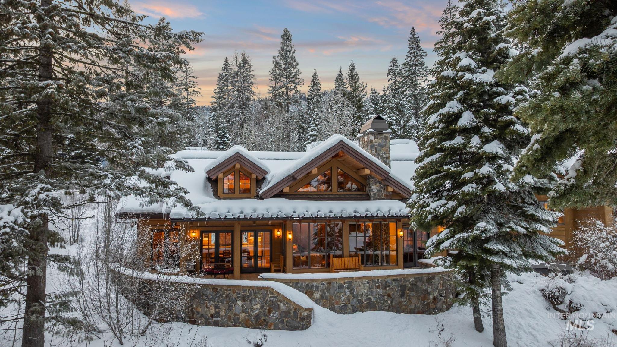 Snow covered back of property featuring covered porch and a chimney