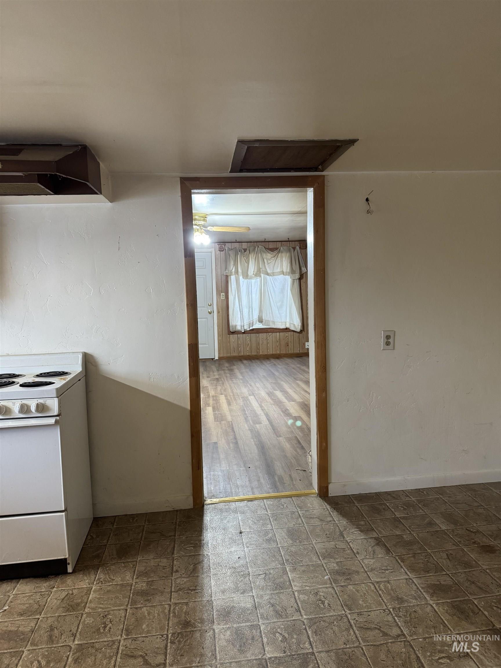 Kitchen with white range with electric cooktop and wall chimney exhaust hood