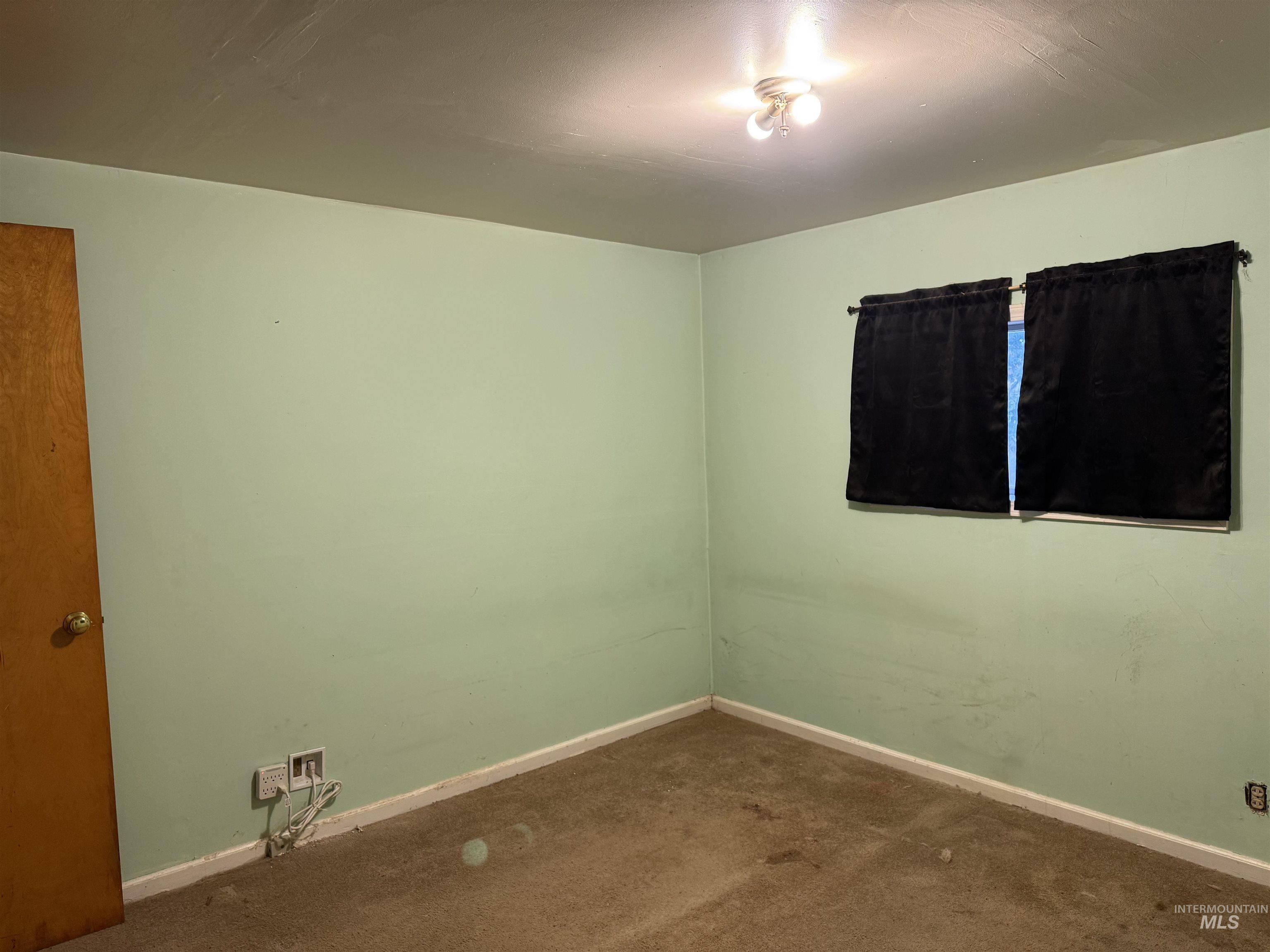 Carpeted spare room with baseboards