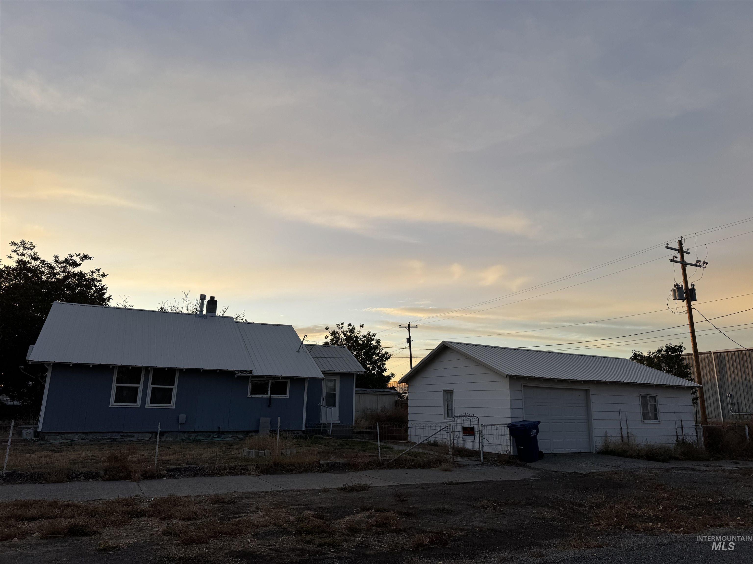 Ranch-style home featuring an outbuilding, a detached garage, and a metal roof