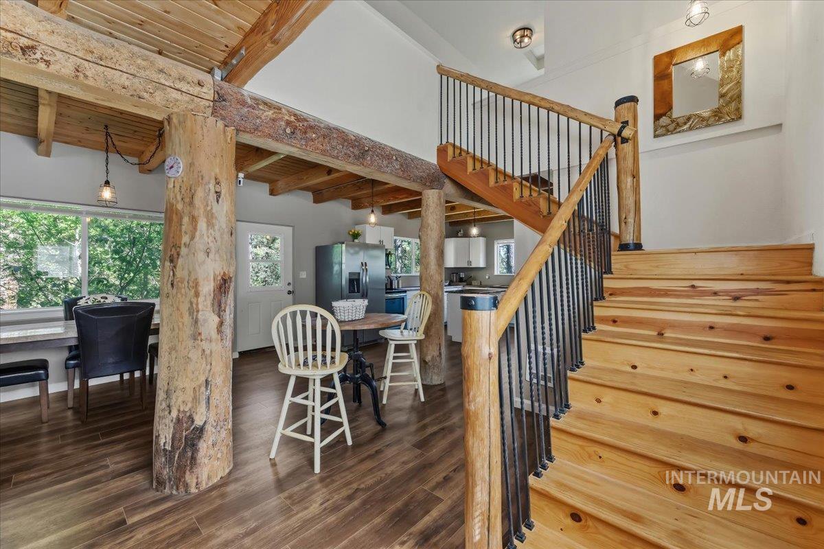 Rustic-inspired staircase featuring light wood treads and risers, black metal balusters, and wood newel posts and handrail