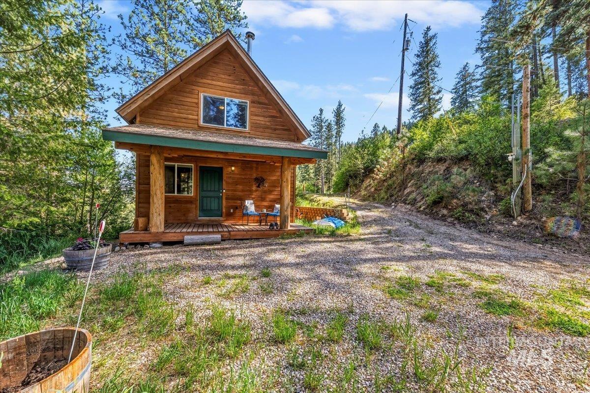 Wood-sided cabin featuring a covered porch with natural wood posts