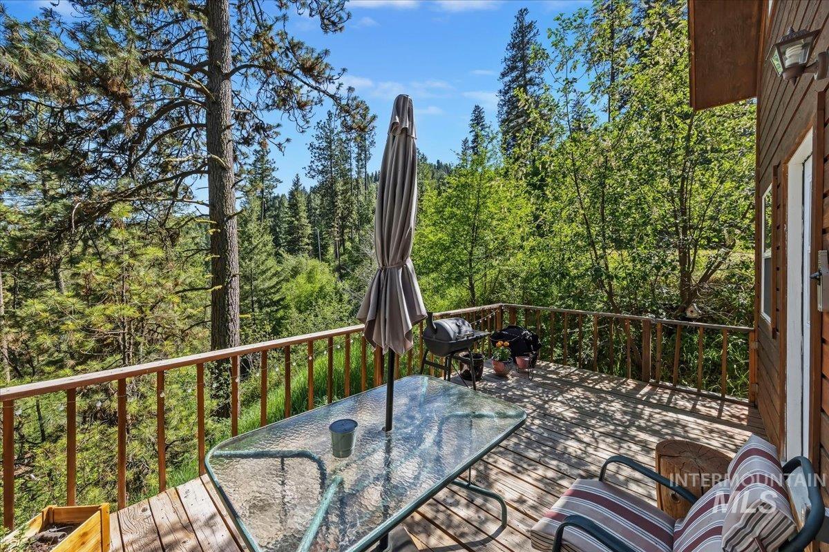 Wood-finish deck with a rustic wooden railing and a glass-top table