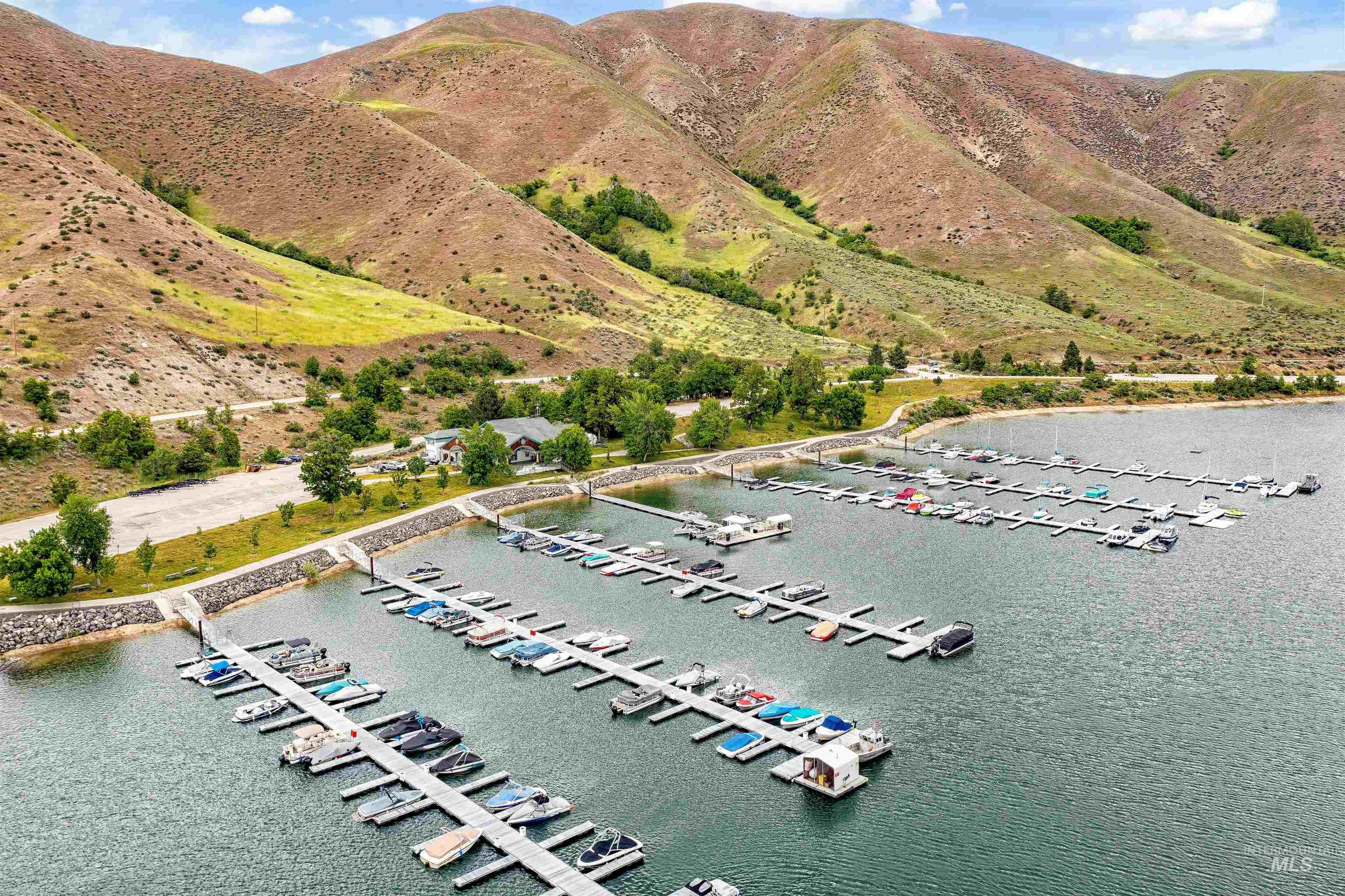 Marina with multiple boat slips, backed by rolling hills