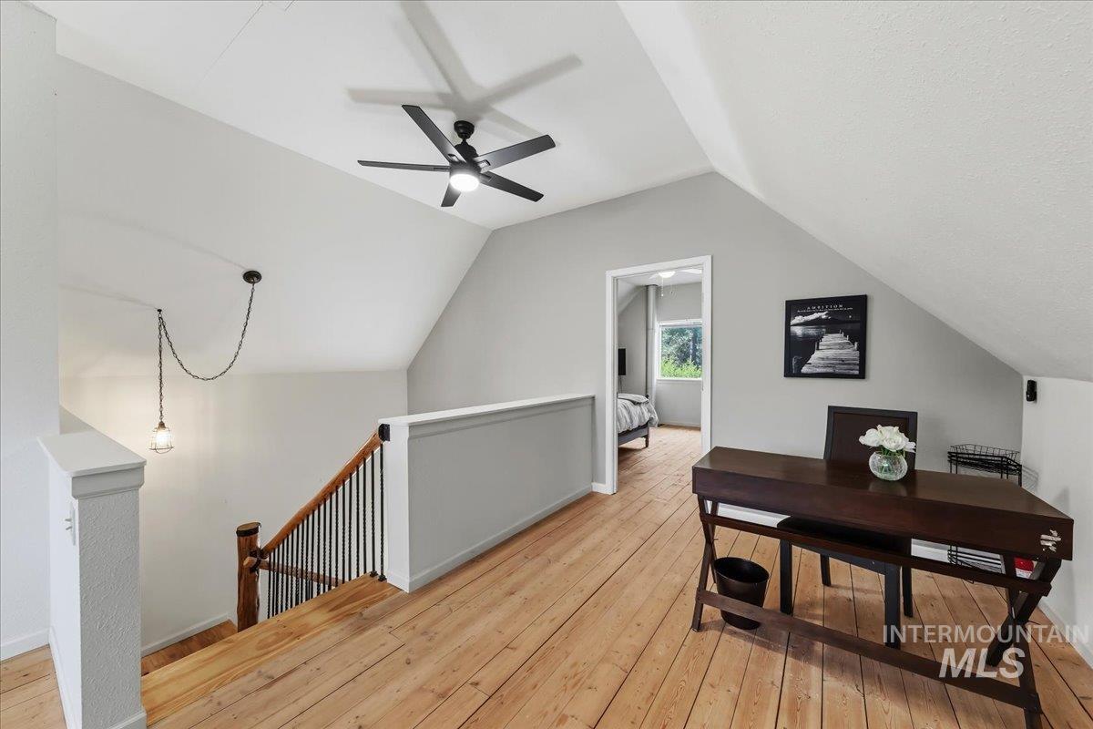 Upper-level area featuring wood-finish flooring, a contemporary ceiling fan, and a light gray wall finish
