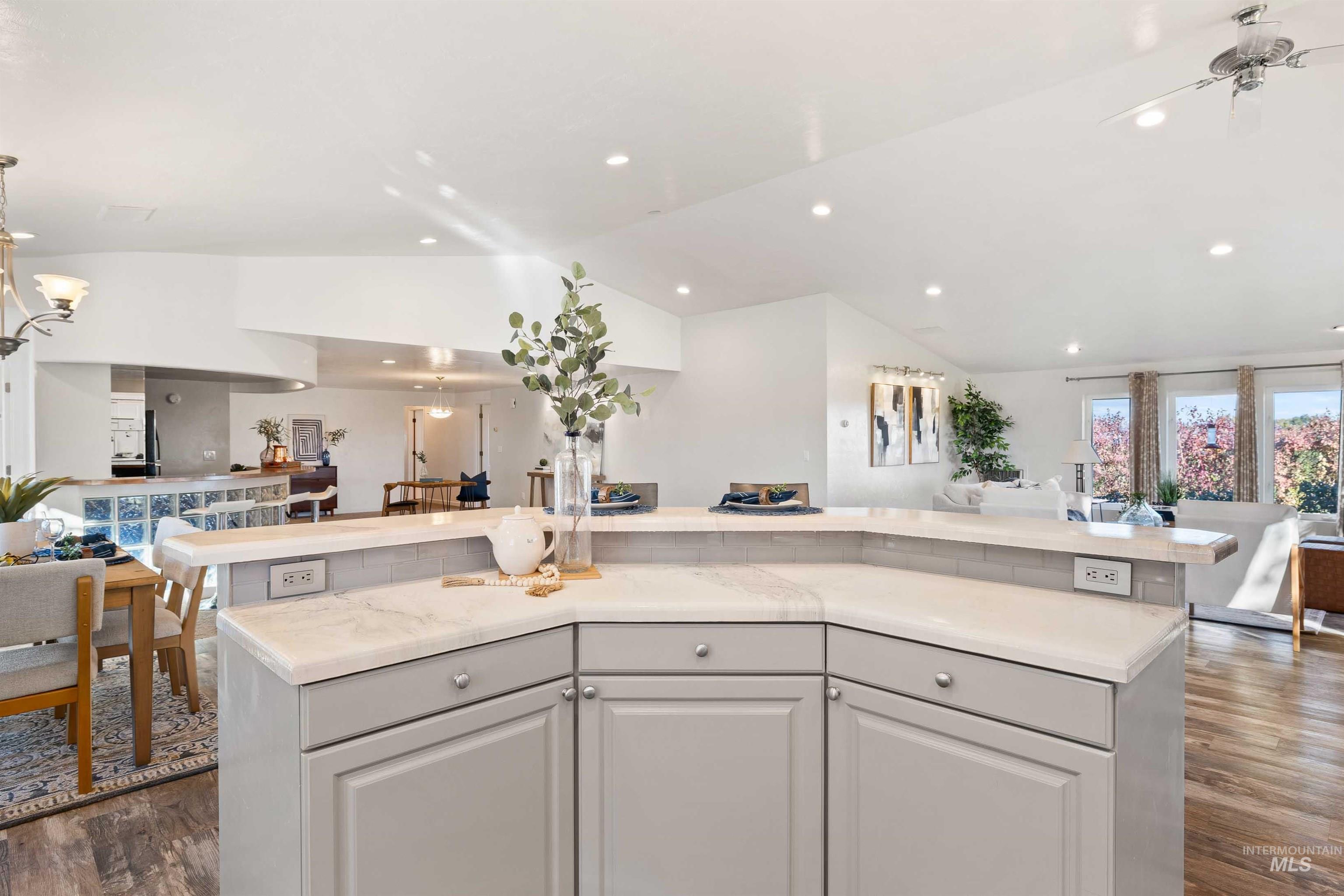 Kitchen with open floor plan, dark wood-type flooring, lofted ceiling, a kitchen island, and recessed lighting