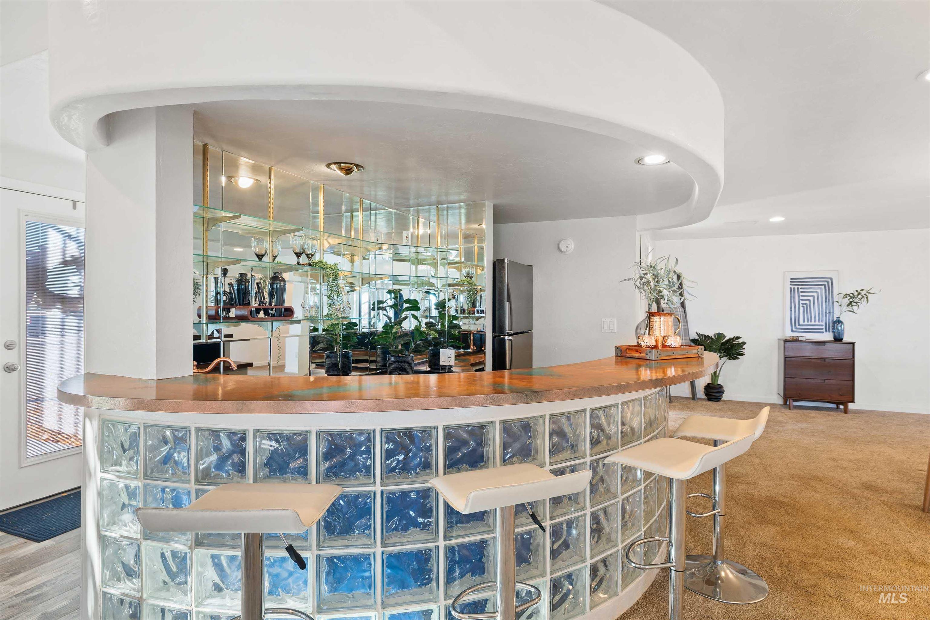Indoor wet bar featuring freestanding refrigerator and recessed lighting