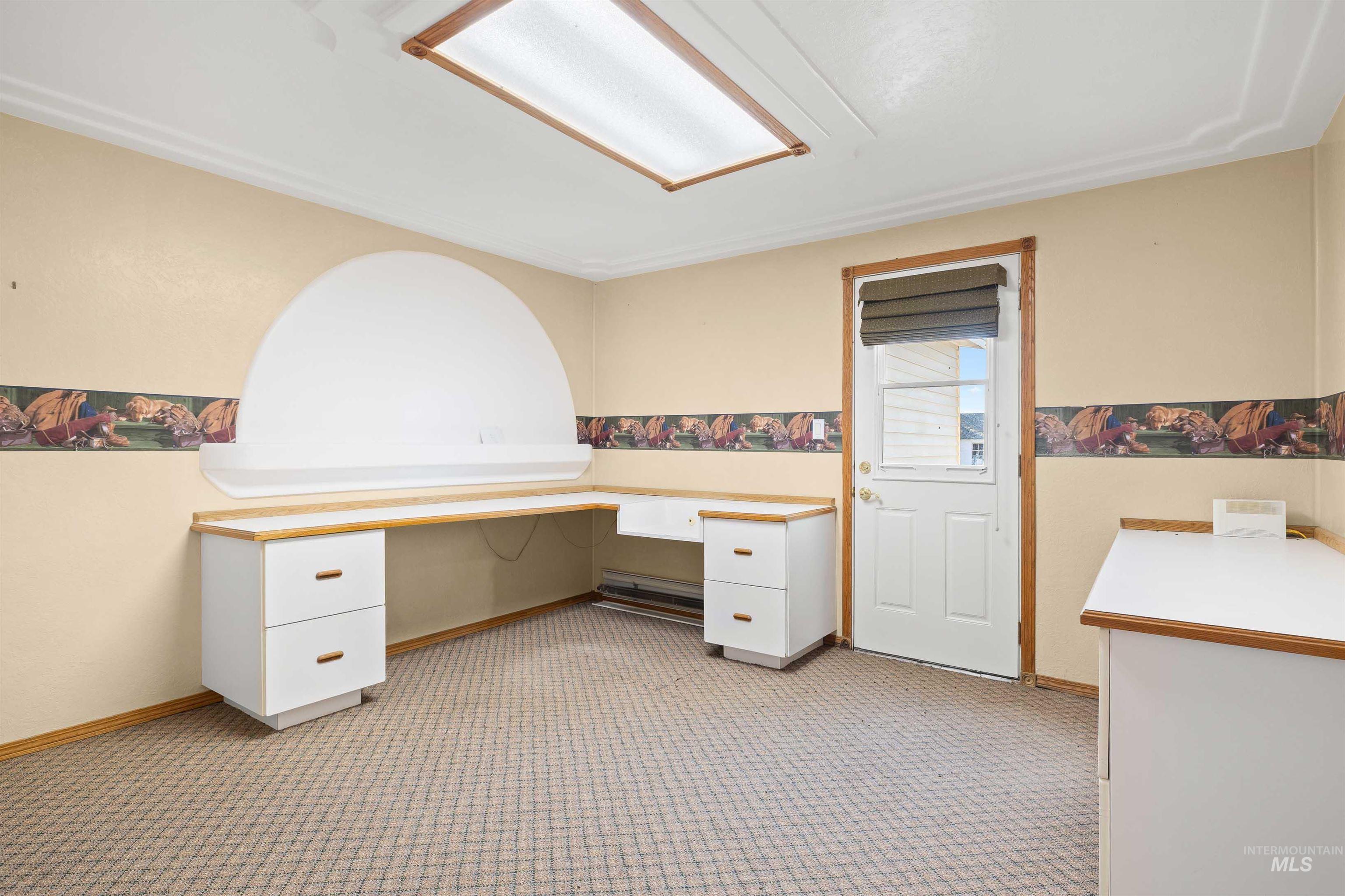 Office space featuring built in study area and light colored carpet