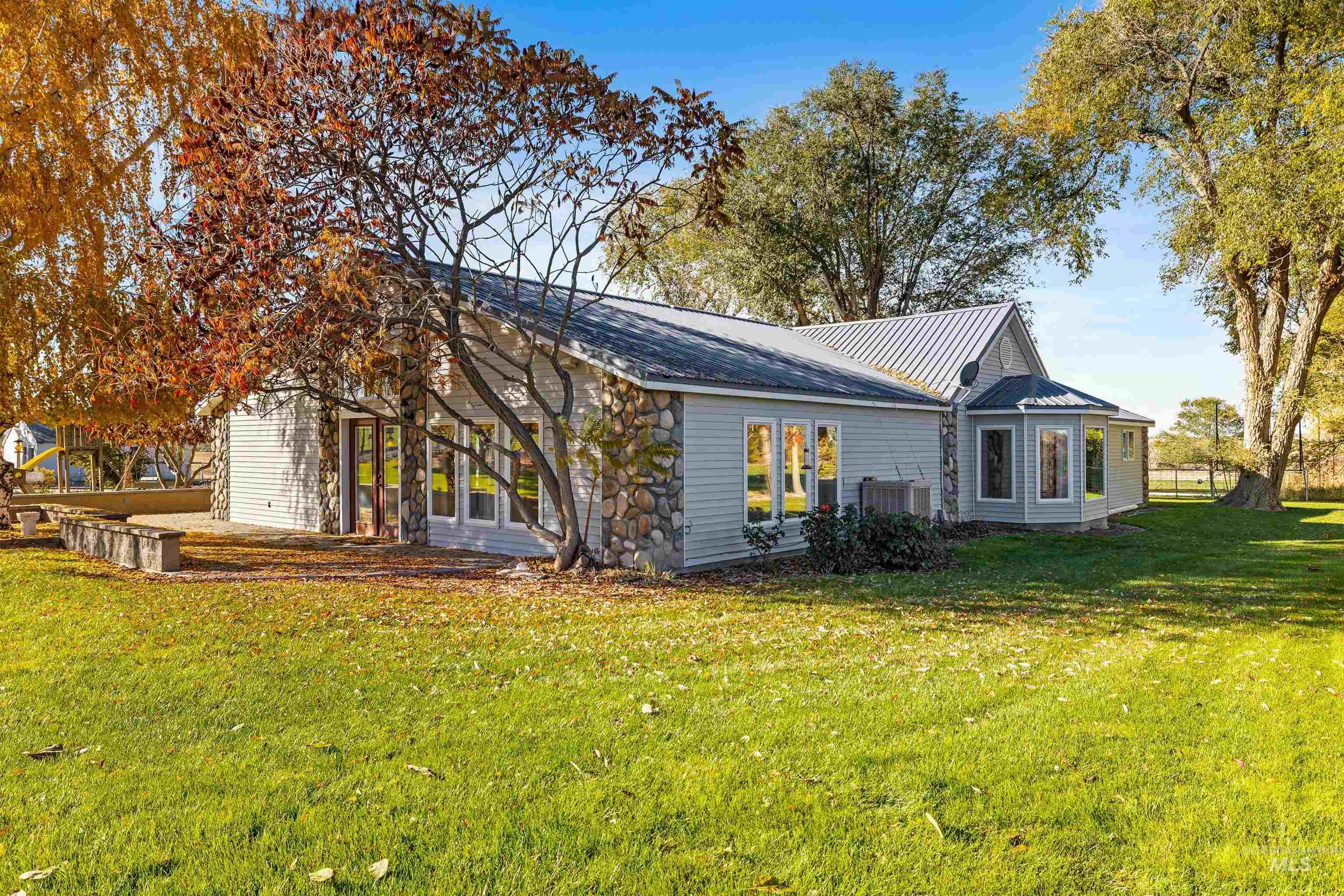 View of home's exterior with a yard and a metal roof