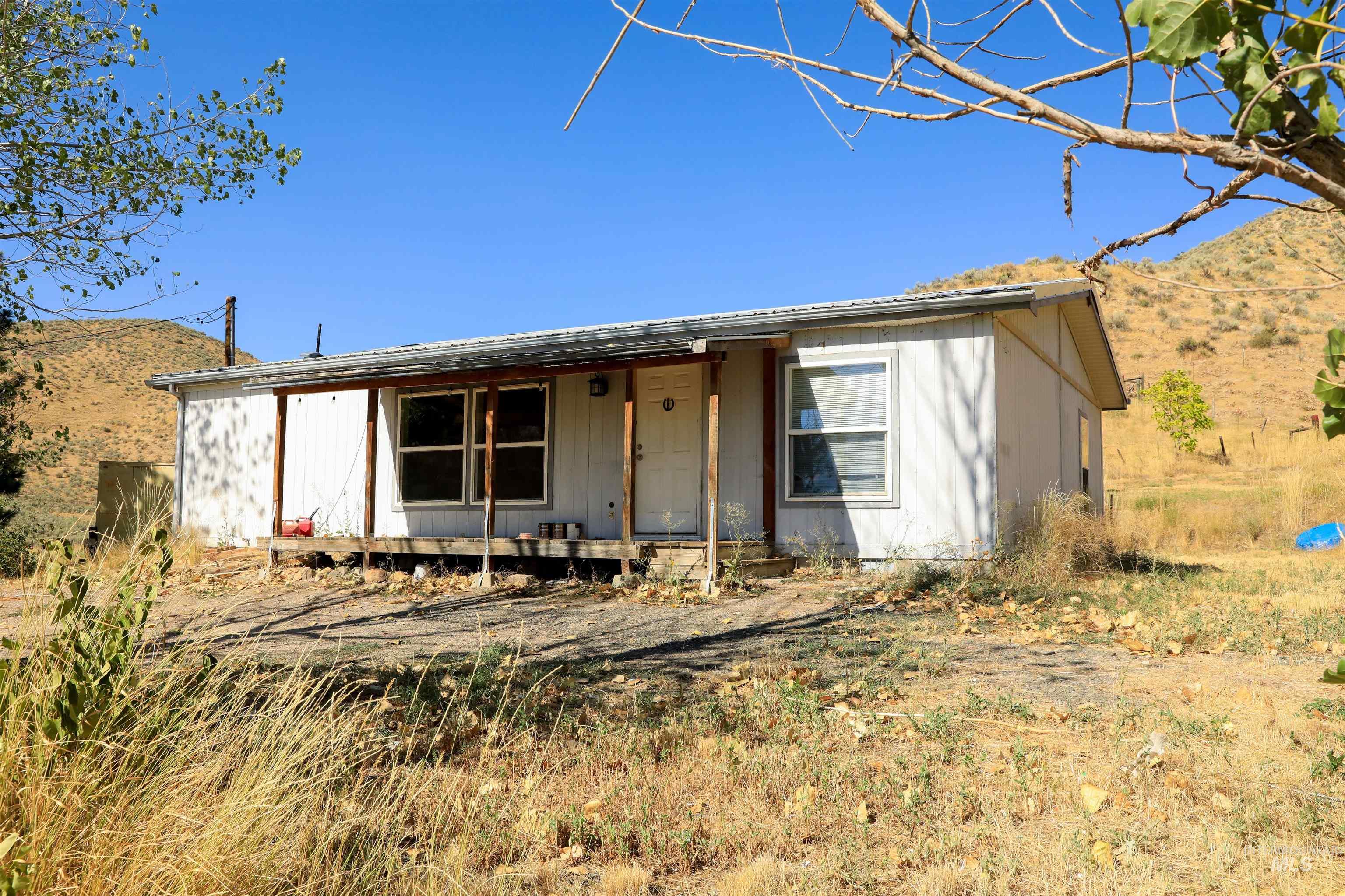 Single story home with a porch, a mountain view, and a metal roof