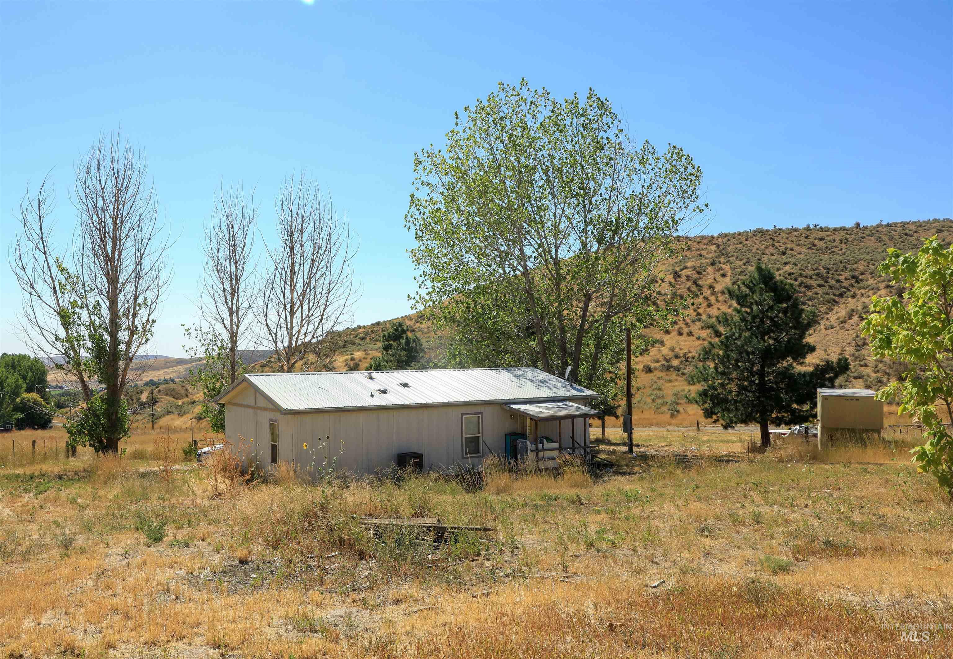 View of yard featuring an outdoor structure, an outbuilding, a rural view, and a mountain view