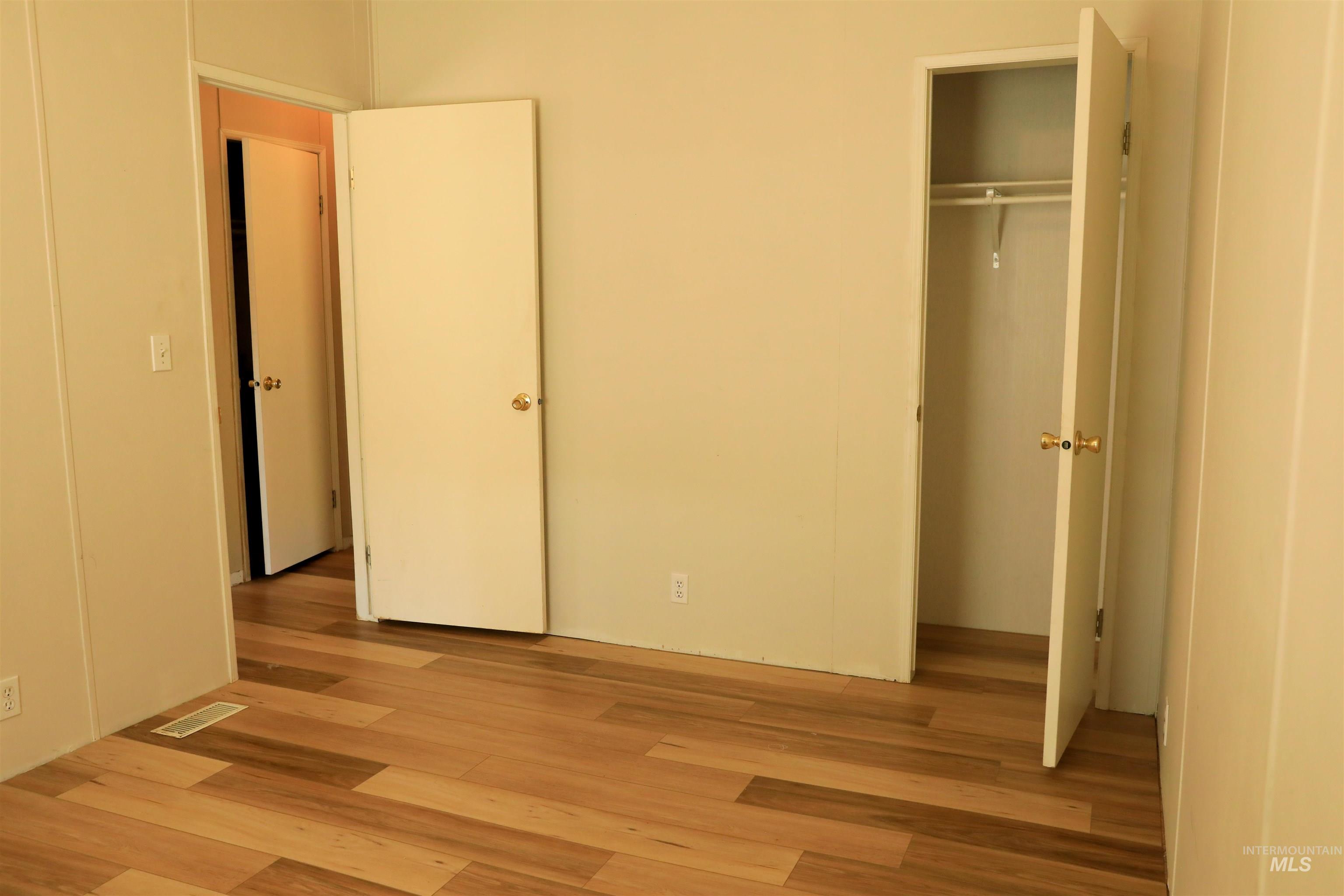 Unfurnished bedroom featuring light wood-style flooring and a closet