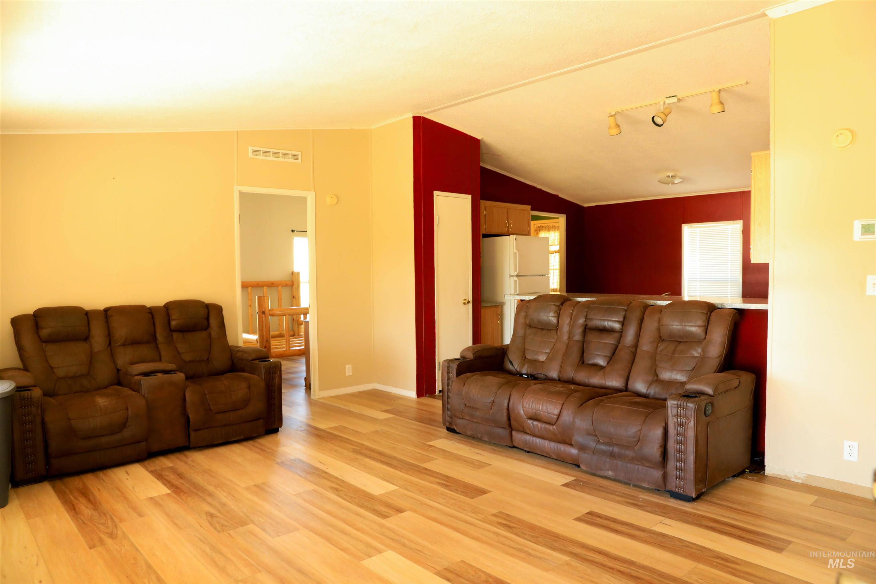Living room featuring lofted ceiling and light wood-style flooring