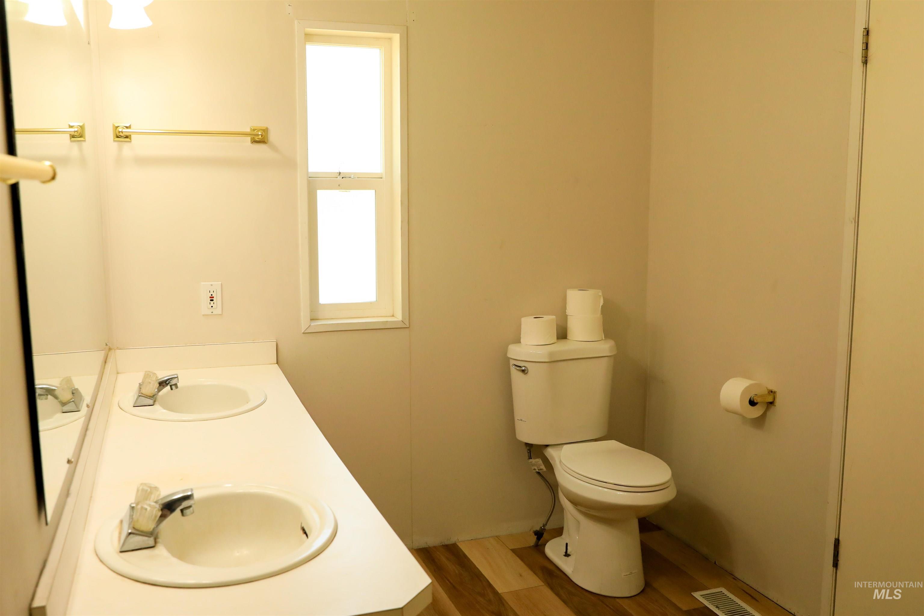Bathroom featuring light wood-style flooring and double vanity