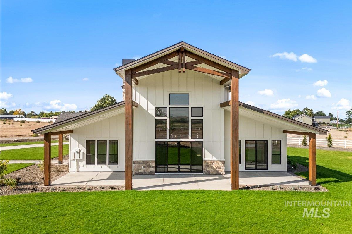 Rear view of property featuring a yard, board and batten siding, and covered porch
