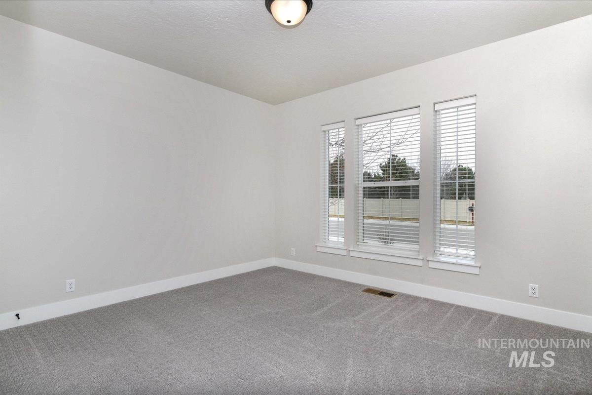 Carpeted spare room with baseboards