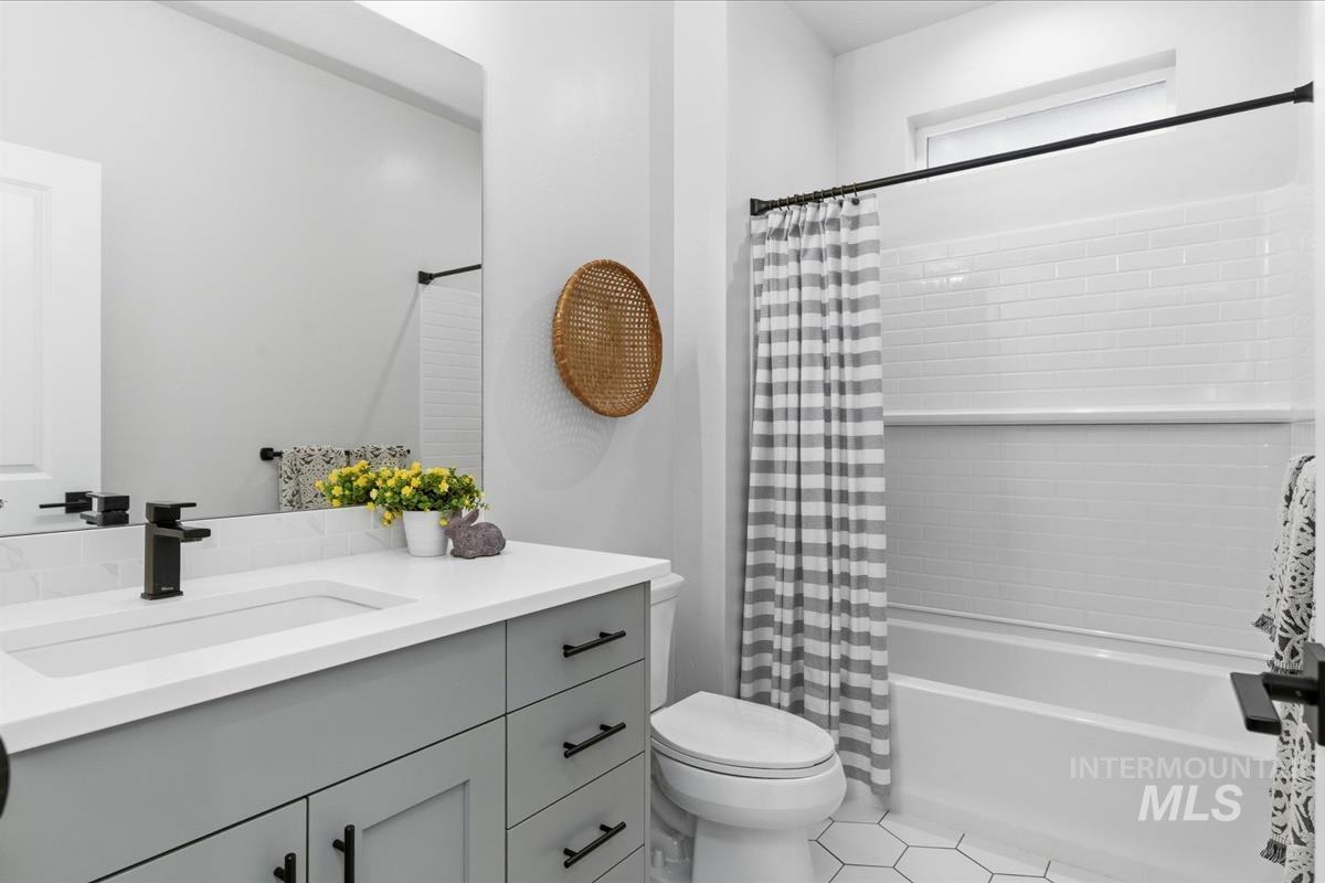 Full bathroom featuring vanity, shower / tub combo, and light tile patterned floors