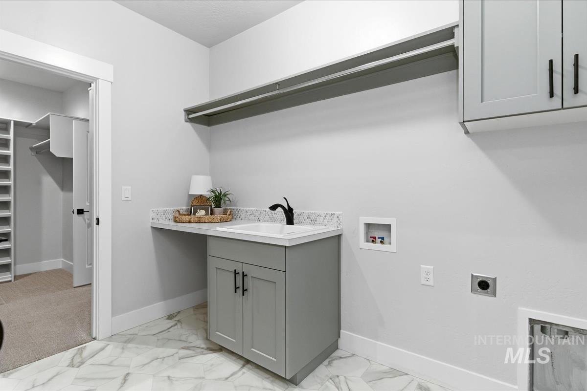 Laundry room with cabinet space, washer hookup, light marble finish flooring, and electric dryer hookup