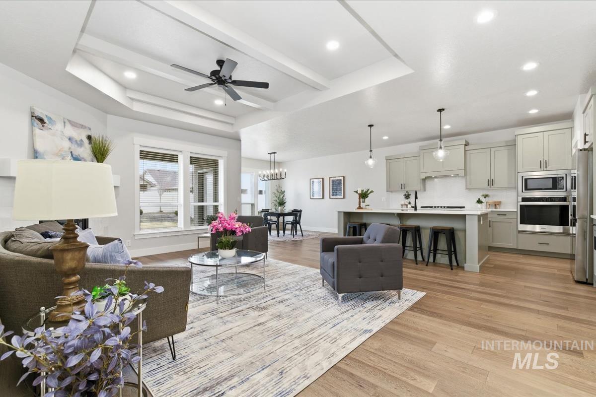 Living area with ceiling fan, light wood-style floors, and recessed lighting