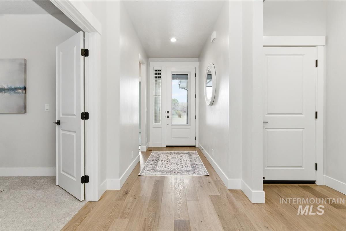 Doorway with wood finished floors and recessed lighting