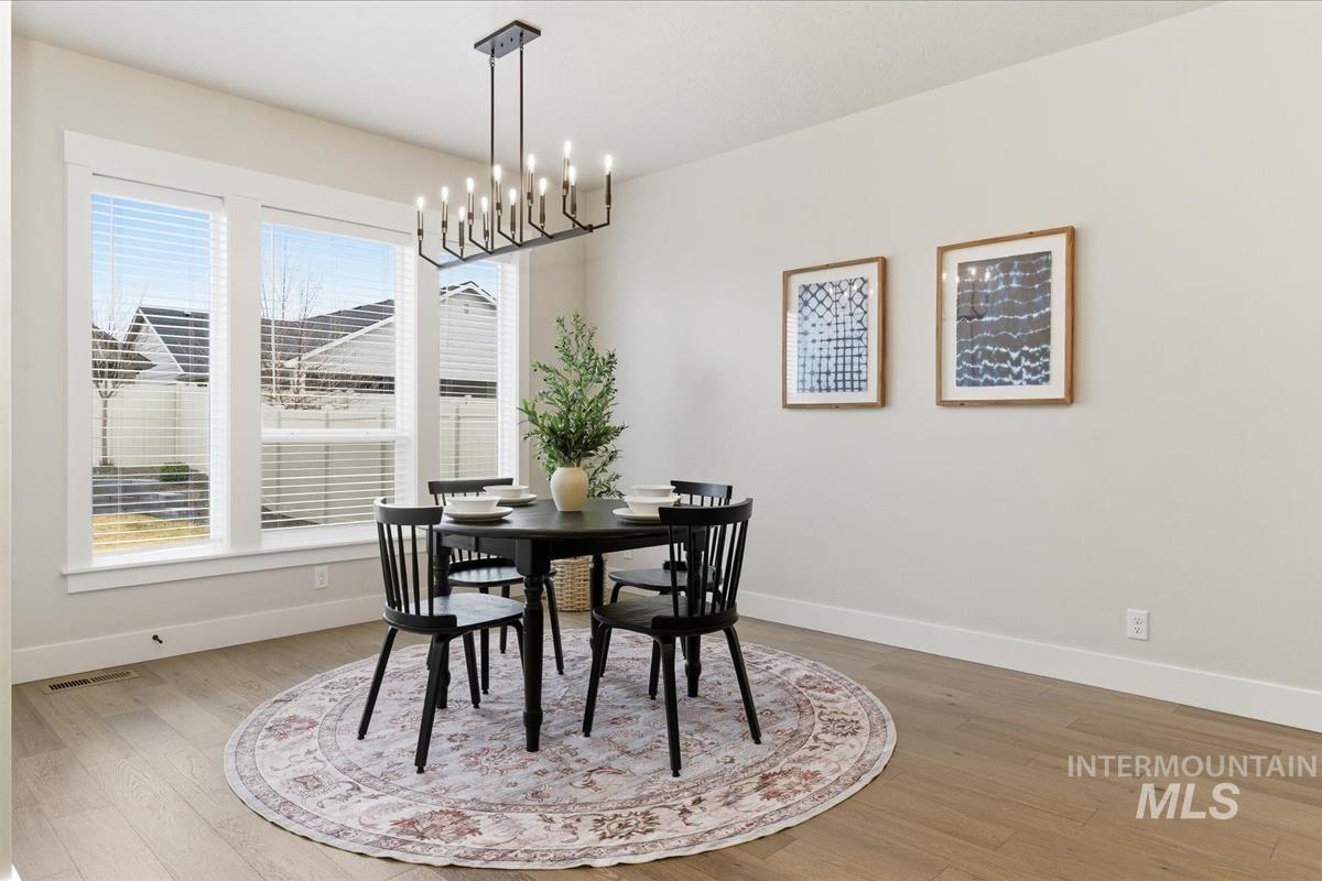 Dining room with light wood-style flooring and hanging lights