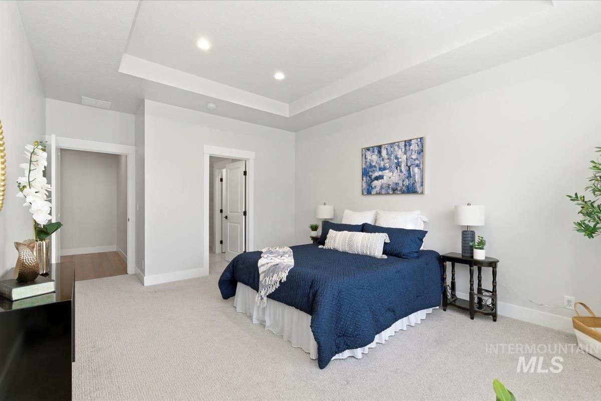 Bedroom featuring a raised ceiling, carpet flooring, and recessed lighting