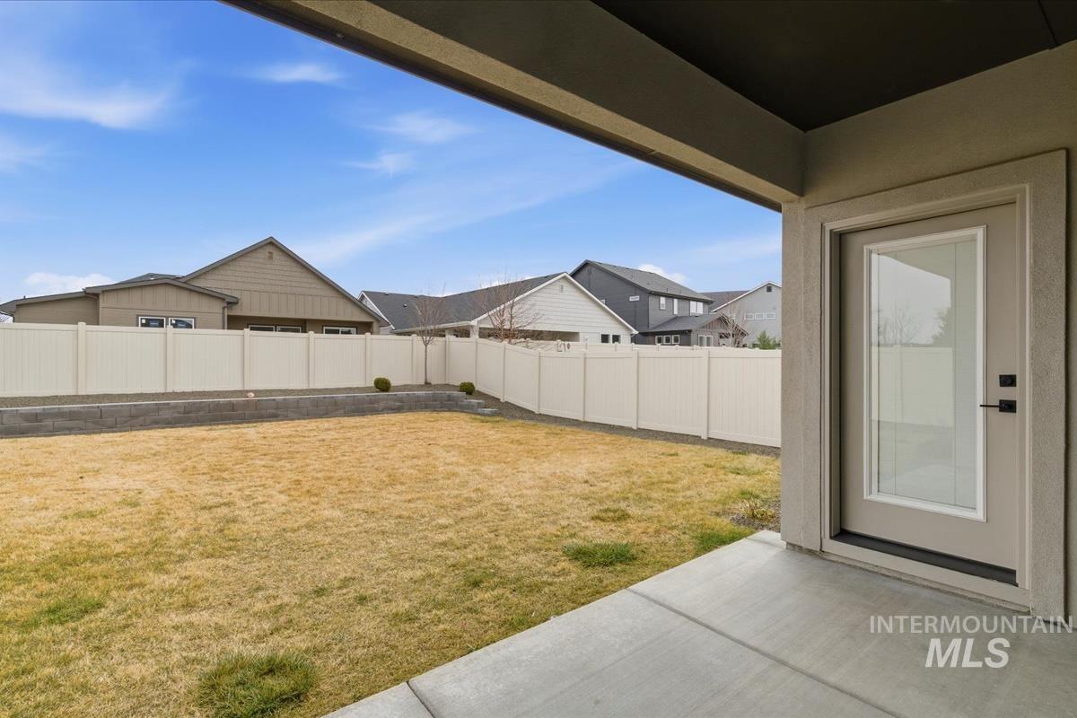 Fenced backyard featuring a patio area and a residential view