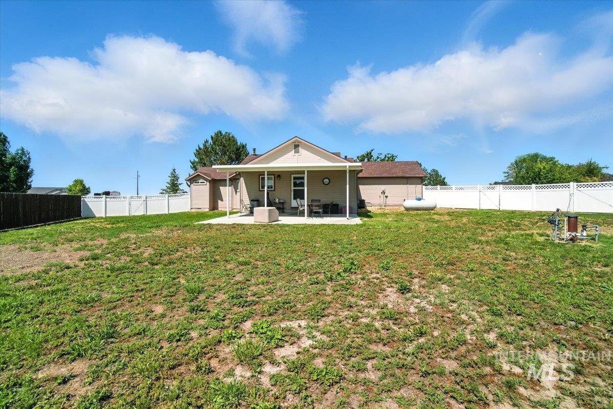 Rear view of house featuring a patio and a fenced backyard
