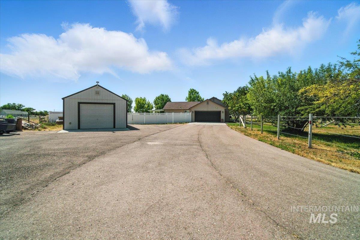 View of front of house featuring a garage and an outbuilding