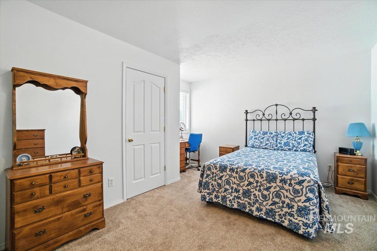 Bedroom featuring carpet flooring and a textured ceiling