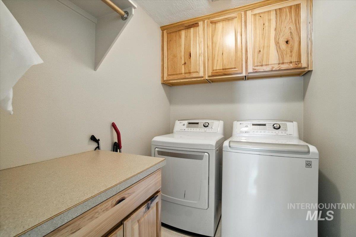 Washroom featuring independent washer and dryer and cabinet space
