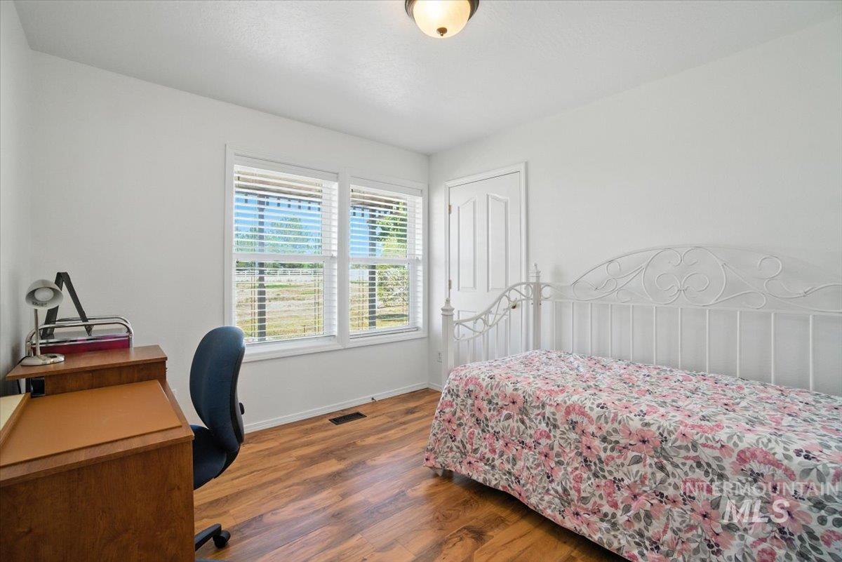 Bedroom featuring wood finished floors and a desk