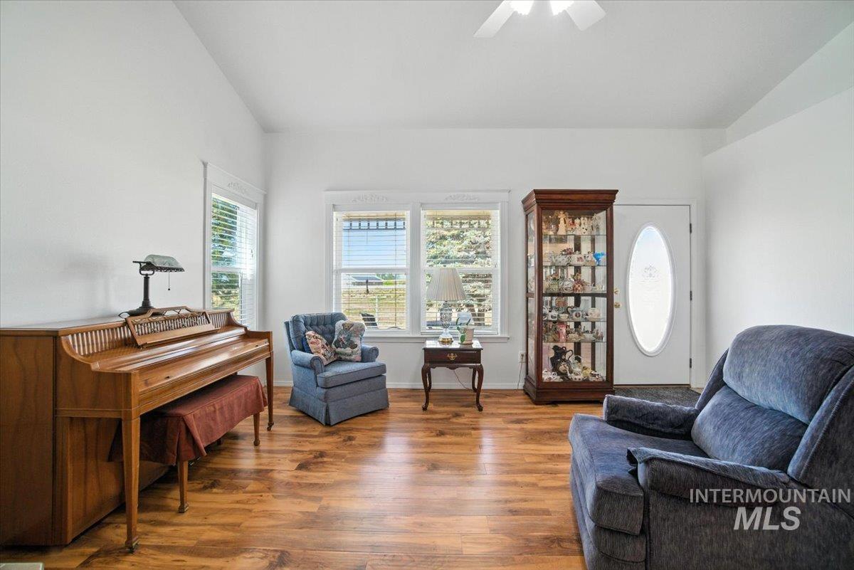 Sitting room featuring wood finished floors, a ceiling fan, and lofted ceiling