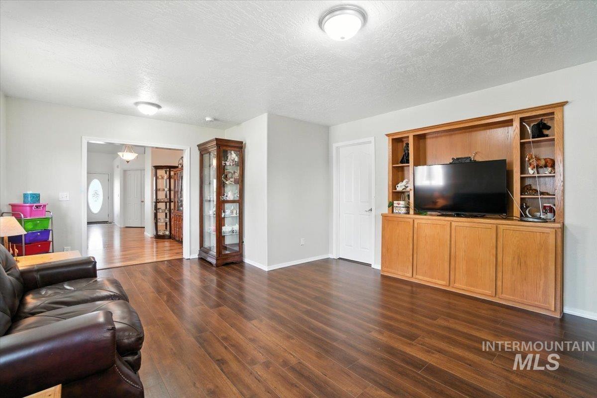 Living area featuring dark wood-type flooring and a textured ceiling