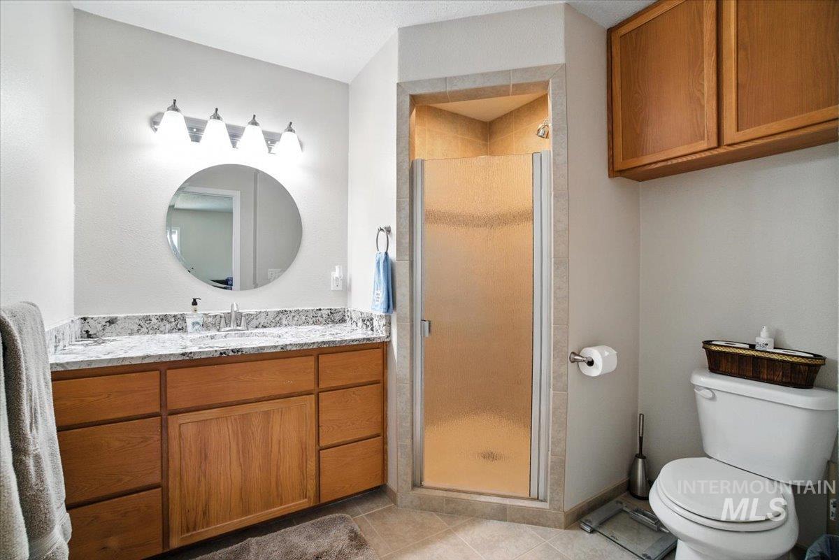 Bathroom featuring vanity, a stall shower, and tile patterned floors