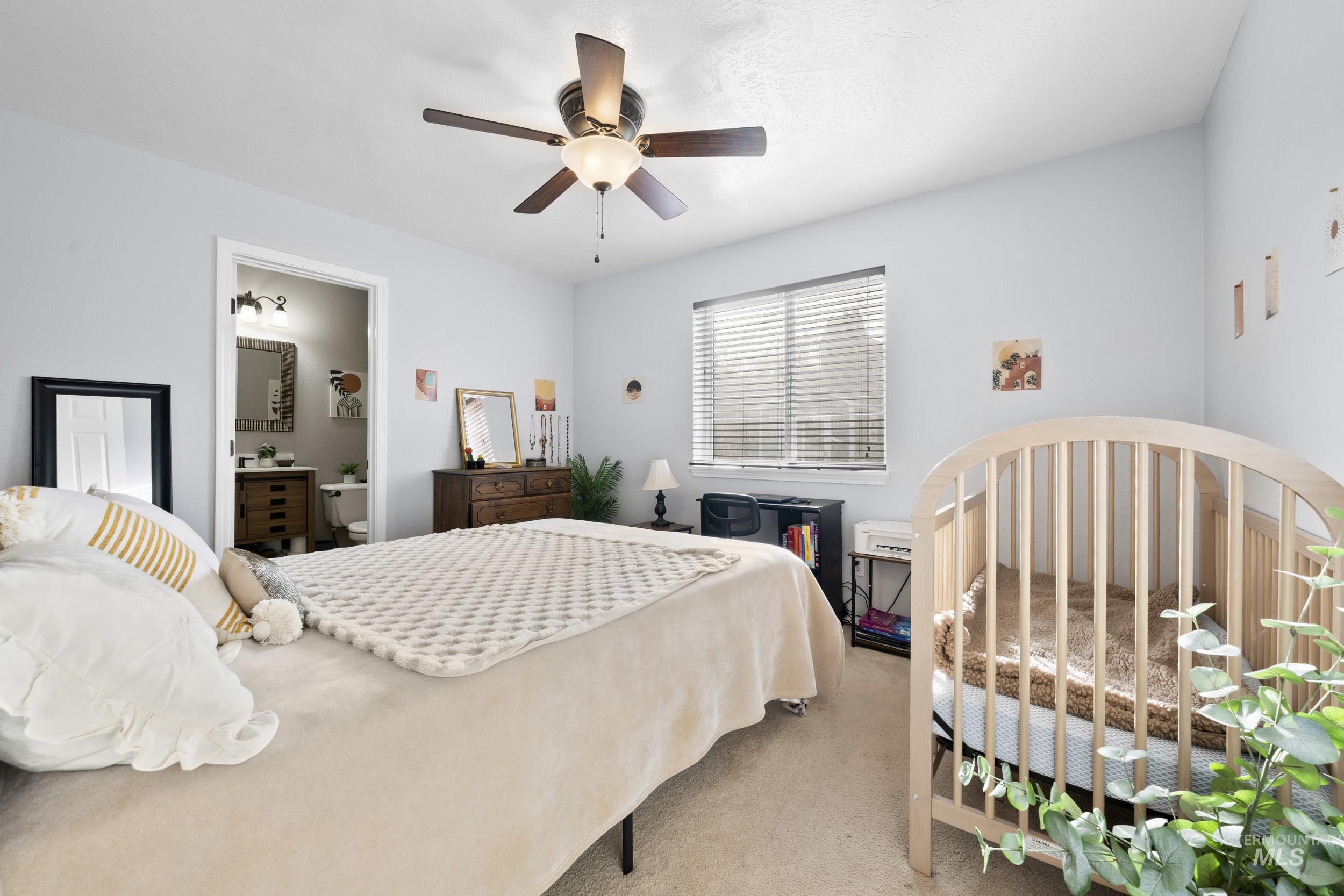 Carpeted bedroom featuring a ceiling fan