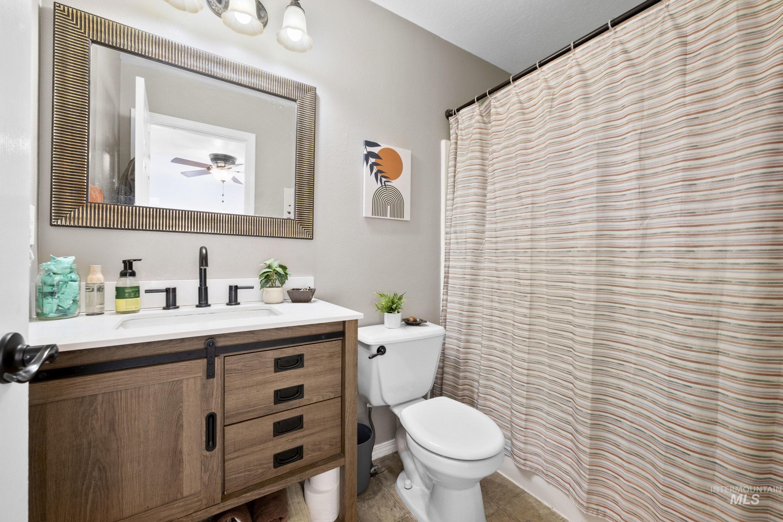 Full bathroom featuring curtained shower and vanity