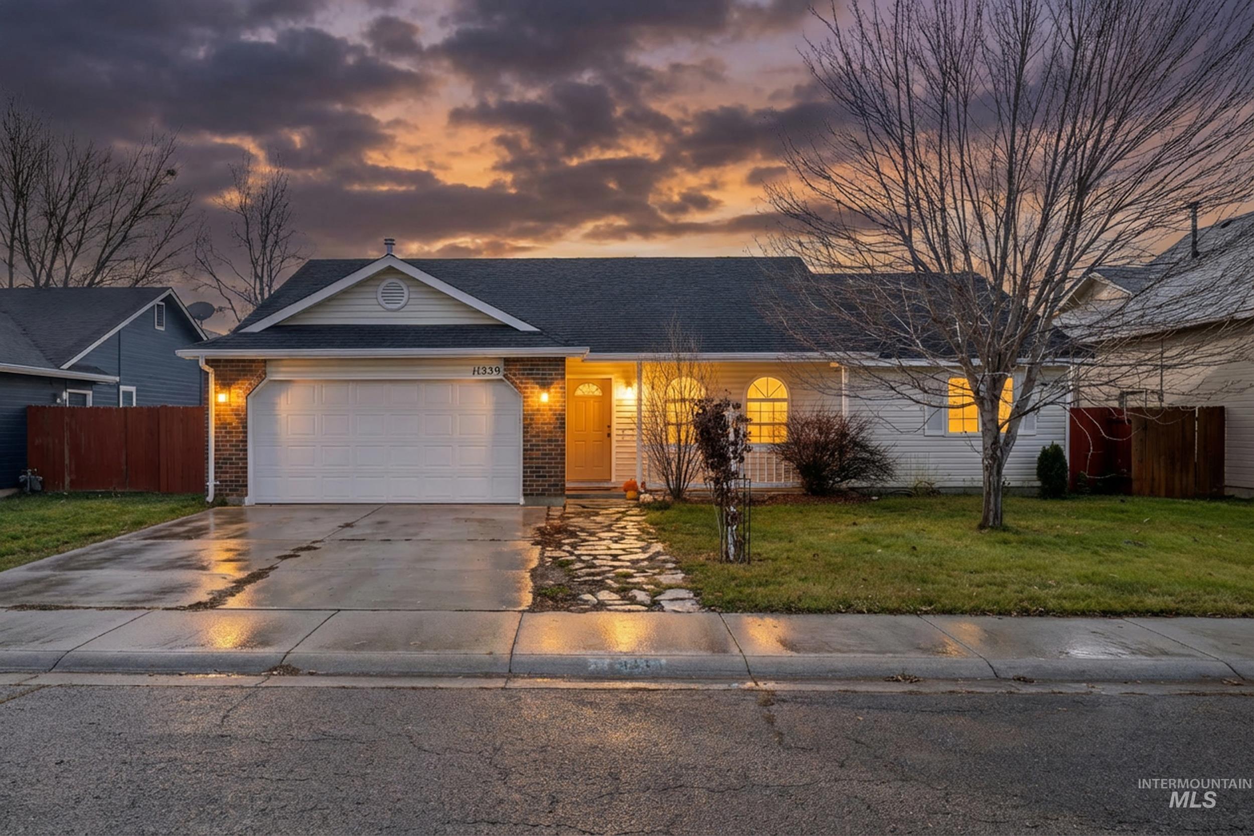 View of front of property with driveway, a garage, and brick siding