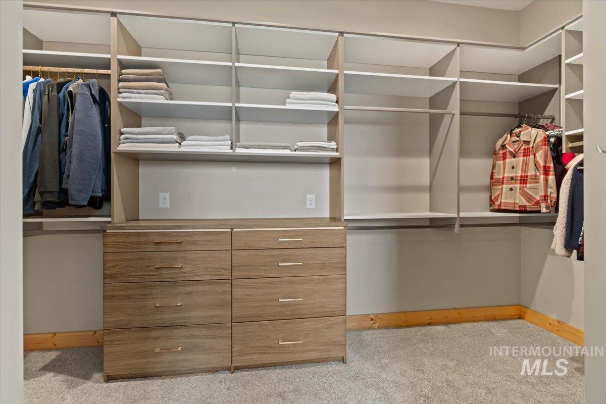 Spacious closet with light carpet