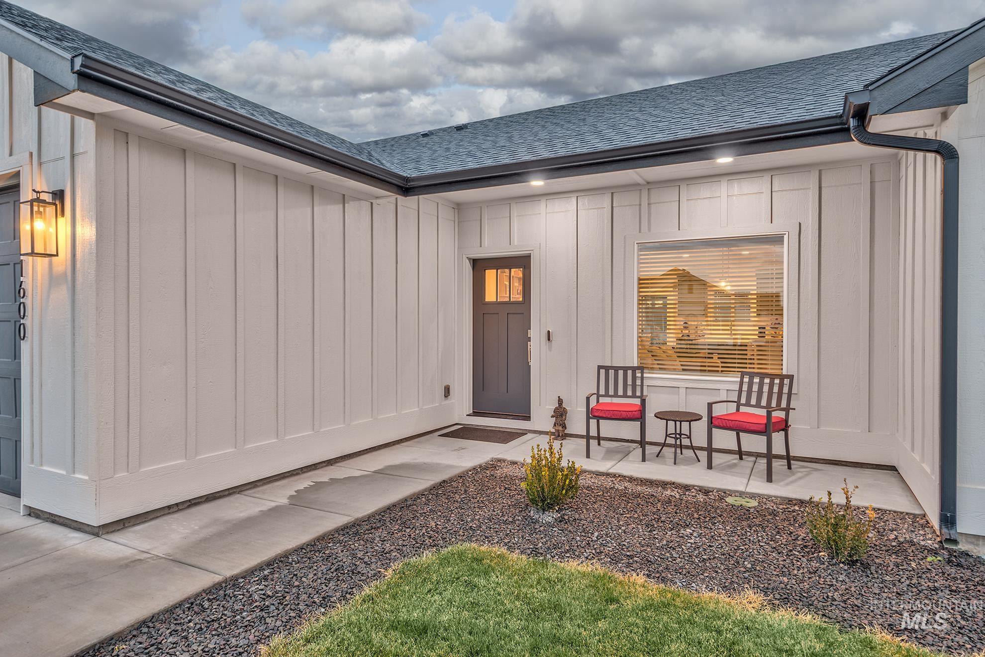 Doorway to property featuring roof with shingles and board and batten siding