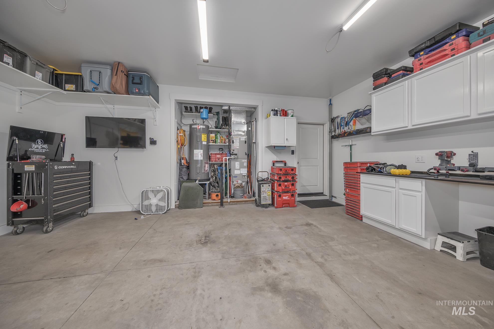 Garage featuring water heater and heating unit