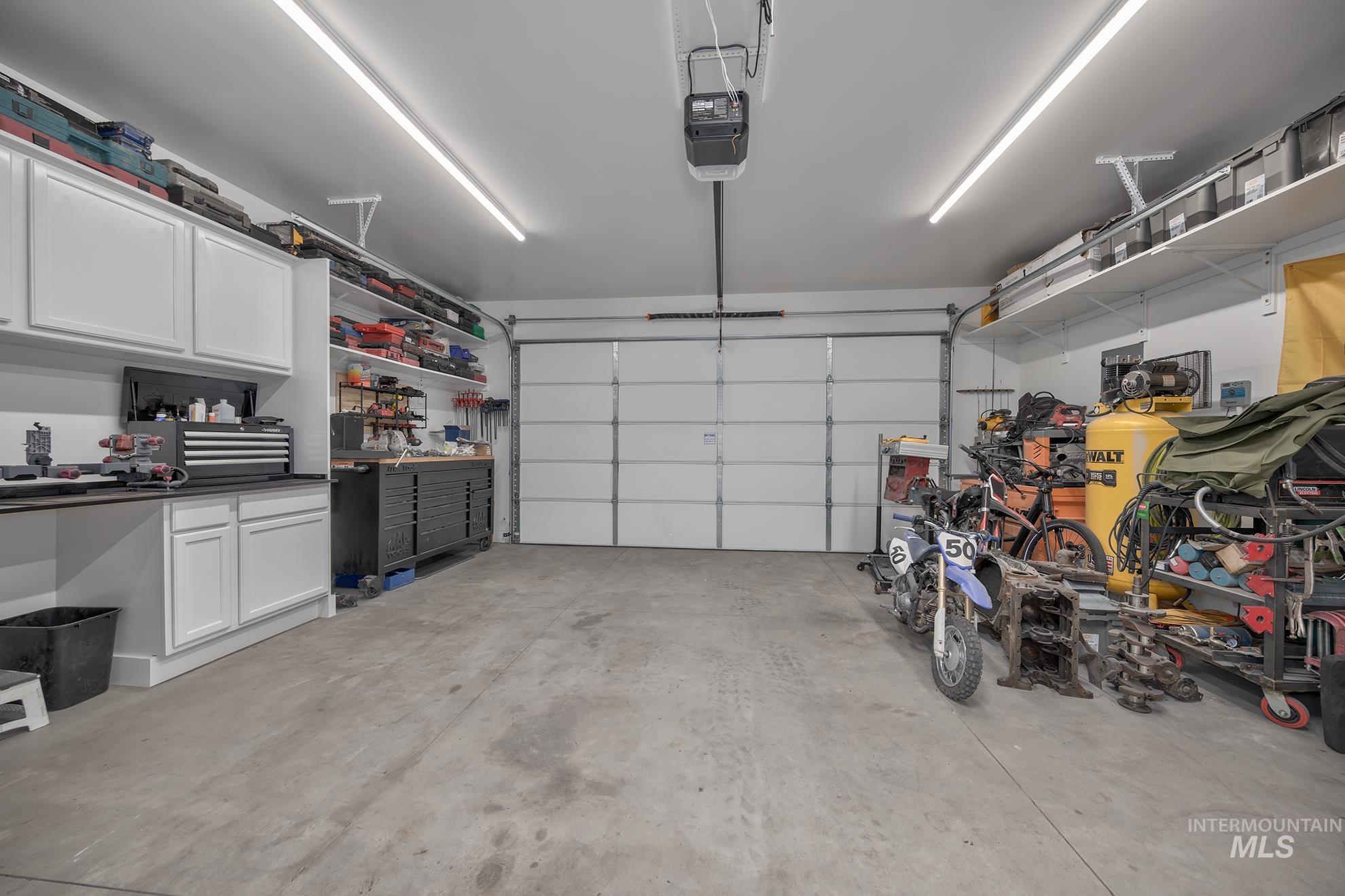 Garage featuring a garage door opener and a workshop area